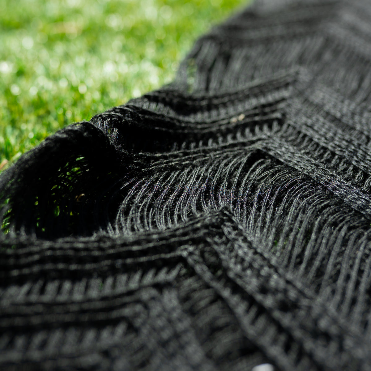 Schwarzes Strandkleid mit feinem Strukturmuster und ausgefransten Kanten am Stoffdetail